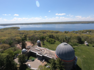 An aerial view of Yerkes Observatory on a sunny day with Geneva Lake in the background.