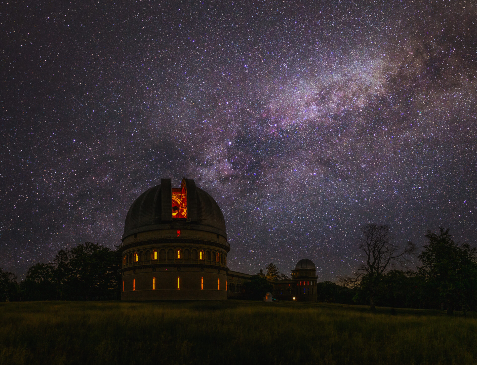 Yerkes Observatory at night with the dome shutter open and the Milky Way in the sky.