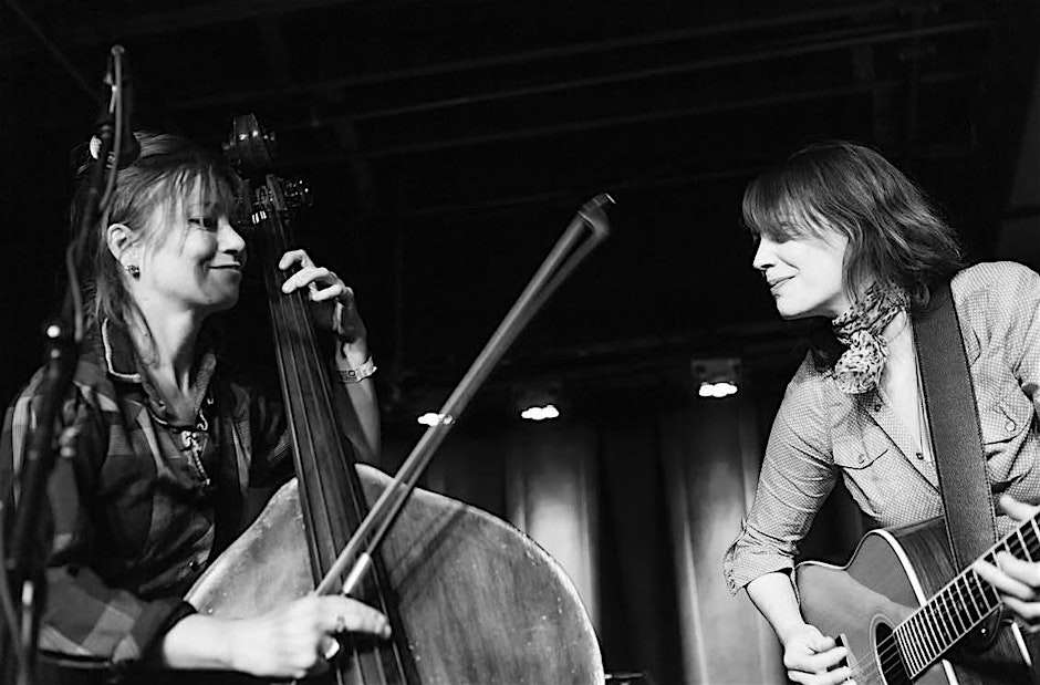 Black and white photo with two people playing musical instruments.
